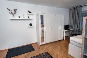 a white bedroom with a closet and a desk at Lovely studio in Augsburg in Augsburg