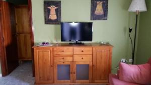 a television on top of a wooden dresser in a room at Apartamento Mayte in Conil de la Frontera