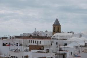 a group of white buildings with a church tower at Apartamento Mayte in Conil de la Frontera