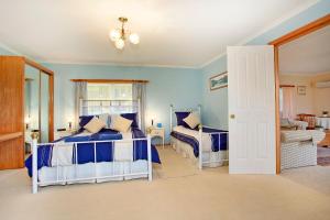 2 camas en un dormitorio con paredes azules en Tamar River Retreat, en Kayena