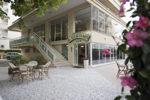 a building with a table and chairs in front of it at Hotel San Giacomo in Cesenatico