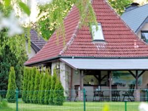 una casa con tetto rosso e recinzione di Ferienhaus am Klostergrund a Malchow