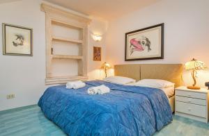 a bedroom with a blue bed with towels on it at Villa Leora Dubrovnik in Dubrovnik