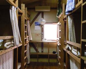 屋久島にあるとまり木の木製の棚と窓が備わるお部屋