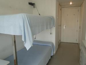 a small room with a bed with a blue blanket at Residència Universitària Sant Joan in Reus