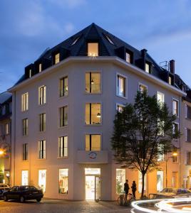 un gran edificio con gente parada fuera de él en Ferienwohnungen am Theater Freiburg, en Freiburg im Breisgau