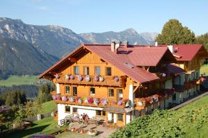 a large house with flowers on the balconies of it at Hotel Breilerhof in Schladming