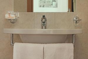 - Baño con lavabo y toallas blancas en Hotel Silvia, en Misano Adriatico