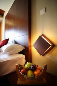 蒙納的住宿－大廣場酒店，睡床旁的桌子上放一碗水果