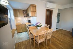 Maria Apartments في تارتو: مطبخ وغرفة طعام مع طاولة وكراسي خشبية