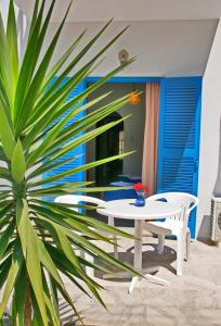 a white table and a chair and a plant at Pension Piertzovani in Parikia