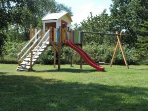 einen Spielplatz mit Rutsche im Gras in der Unterkunft Lovely Apartment in Neubukow near Sea in Neubukow