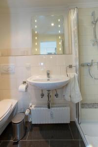 a bathroom with a sink and a toilet and a mirror at Seewind in Sankt Peter-Ording