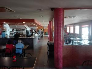 un restaurante con un pilar rojo, mesas y sillas en Hotel Restaurant Casa Miquel, en Alcarraz