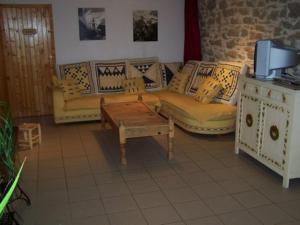 a living room with couches and a coffee table at Le Gîte de l'Ourserie in Méaudre