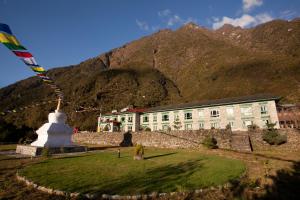 un bâtiment avec une montagne en arrière-plan et un bâtiment dans l'établissement Mountain Lodges of Nepal - Lukla, à Lukla