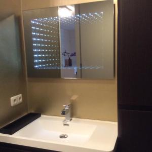 een badkamer met een wastafel met een spiegel en een spiegel bij Beach Suites Lemmer in Lemmer