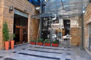 a glass storefront with potted plants in front of a building at Bashtamal Hotel Suites in Amman