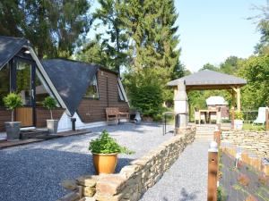 une maison avec une clôture en pierre et un kiosque dans l'établissement Alluring Chalet in Gesves with Roof Terrace Garden BBQ, à Gesves