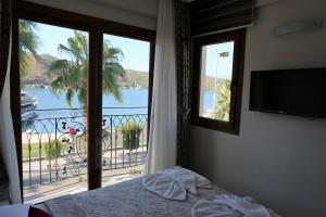 a bedroom with a bed and a balcony with a view at Q&S Cennet Life Hotel in Fethiye