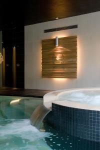 a swimming pool with a jacuzzi tub in a house at Cascina Scova Resort in Pavia