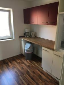 a kitchen with white cabinets and a wooden counter top at Ferienwohnung "Zur Ottoburg" in Schlitz in Schlitz