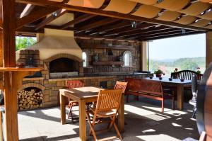 a patio with a stone fireplace and a table and chairs at Casa Bata in Bata