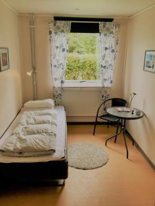 a bedroom with a bed and a table and a window at Hällefors Vandrarhem-Hostel & Kanotcenter in Hällefors