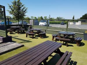 a group of picnic tables and benches on the grass at Hatton's of Garadice in Garadice