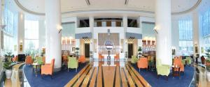 a lobby with tables and chairs in a building at Concorde Hotel Fujairah in Fujairah +37 photos