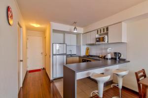 a kitchen with a counter and two stools at Departamento Mondaca Vista Mar in Valparaíso