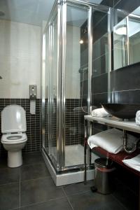 Un baño con ducha, inodoro y lavabo. en Arcohotel, en San Mateo de Gállego