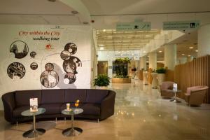 a lobby with a couch and tables in a building at City Hotel Ljubljana in Ljubljana