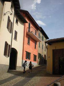 two people walking down a street next to buildings at Appartamento TieMi in Coldrerio