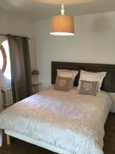 a bedroom with a large bed with two pillows at Gite Place De La Fontaine in Hautvillers