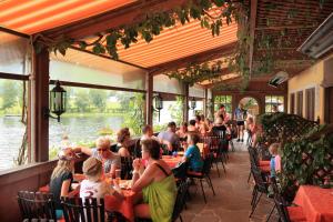a group of people sitting at tables in a restaurant at Appartementhaus Seehof in Kirchberg in Tirol