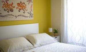 a bedroom with a white bed and a window at Appartamento Scorcio di Mare in Aci Castello