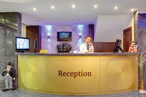 un mostrador de recepción en un hotel con un hombre hablando por teléfono en Susuzlu Seckin Hotel en İzmir