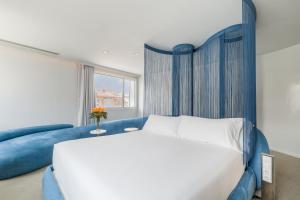 a bedroom with a large bed and a blue couch at Room Mate Oscar, Madrid in Madrid