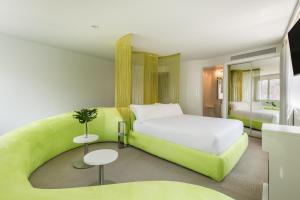 a bedroom with a white bed and a green couch at Room Mate Oscar, Madrid in Madrid
