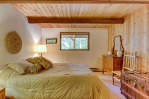 a bedroom with a bed and a wooden ceiling at The Chalet on Lopez in Islandale