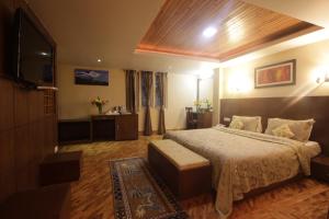 a bedroom with a bed and a flat screen tv at Zone Connect by The Park Mount Siniolchu, Gangtok in Gangtok