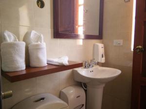 a bathroom with a sink and a toilet and towels at Hotel Campestre Franchesca in Tabio