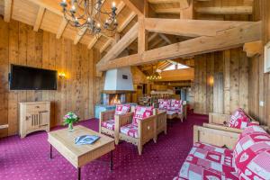 una sala de estar con paredes de madera y alfombra morada. en Le Refuge, en La Rosière