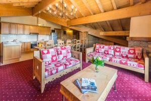 a room with couches and a table and a kitchen at Le Refuge in La Rosière