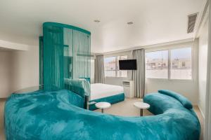 a bedroom with a large blue couch and a bed at Room Mate Oscar, Madrid in Madrid