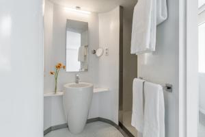 a white bathroom with a sink and a mirror at Room Mate Oscar, Madrid in Madrid