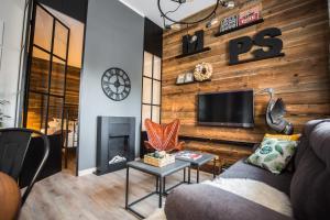 un soggiorno con divano e TV su una parete in legno di Nice Stay 2 a Toruń