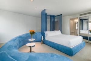 a bedroom with a blue bed and a table at Room Mate Oscar, Madrid in Madrid