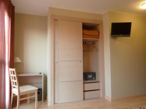 a closet with a door and a chair in a room at Arcohotel in San Mateo de Gállego